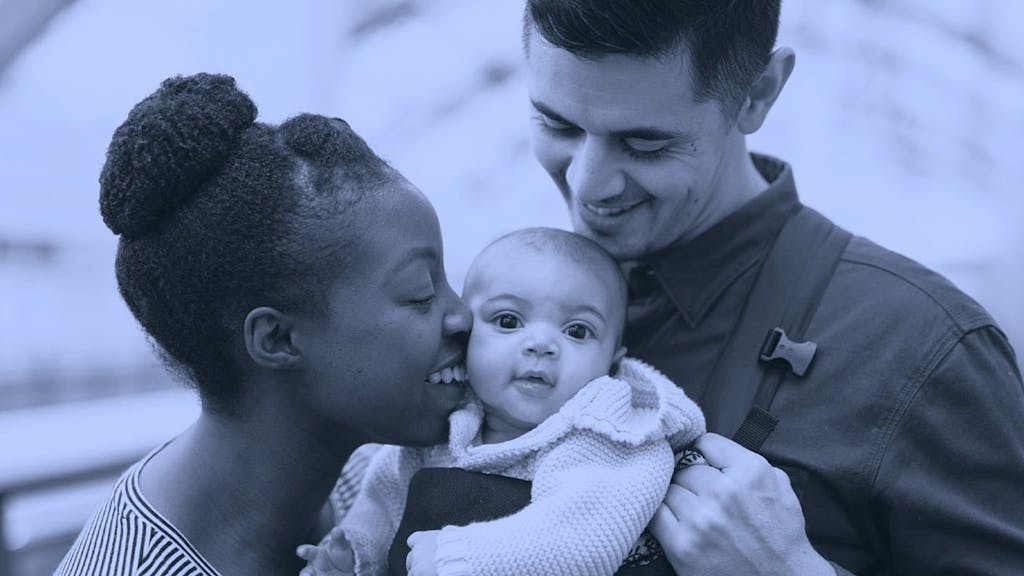 Parents and baby posing for a picture.|Young family posing for a picture.|Tipping Point Community Logo