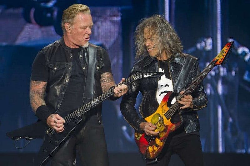 photo of two musicians playing bass guitar on stage together
